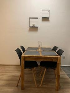 una mesa de madera con sillas y una copa de vino. en Apartmán na náměstí, en Králíky