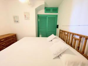 a bedroom with a bed and a green door at Casa Leo - Villaggio Baia De Bahas in Golfo Aranci