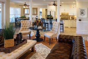 a living room with a couch and a table at New - Spectacular️ Golf Views - Sleeps 20 - Pinehurst National #9 - Near DT Pinehurst! in Pinehurst