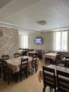 a dining room with tables and chairs and a flat screen tv at Горизонт in Dragobrat