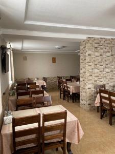 a dining room with tables and chairs and a brick wall at Горизонт in Dragobrat