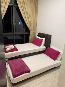 two beds sitting next to a window in a room at Setia Sky 88 Living in the Skies in Johor Bahru