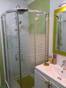 y baño con ducha acristalada y lavamanos. en PISO RONDA, en Granada