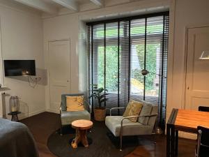 1 dormitorio con 1 cama, 2 sillas y mesa en Stadslogement Westersingel, en Sneek