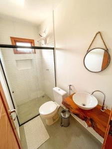 een badkamer met een toilet, een wastafel en een spiegel bij Pousada Brisa Mar in Fernando de Noronha