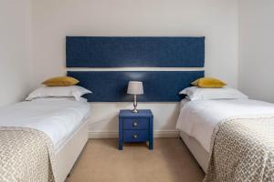 sypialnia z 2 łóżkami i niebieskim zagłówkiem w obiekcie Turnberry accommodation w mieście Turnberry