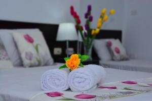 two towels with a flower on top of a bed at Residencial Lago Verde in Tarapoto