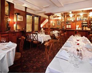 a restaurant with tables and chairs with white tablecloths at Hodgkinsons Hotel Matlock Bath in Matlock
