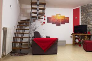 B&B Continanza في Castelsaraceno: غرفة معيشة مع كرسي وبطانية حمراء