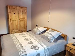 1 dormitorio con 1 cama y armario de madera en La Ferme De Fernand, en Sixt