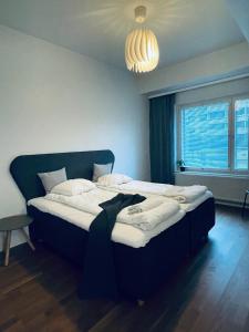 ein großes Bett in einem Zimmer mit Fenster in der Unterkunft STAY Matinkylä Apartments in Espoo