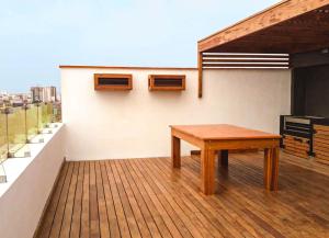 a room with a wooden table on a roof at Encantador Loft en Lima - Cerca del aeropuerto in Lima