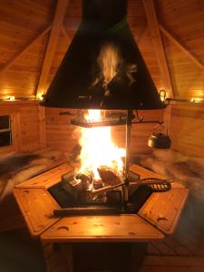 un camino in una cabina con un fuoco dentro di Modern Lapland Cottage with Outdoor Sauna & BBQ Hut a Slagnäs