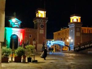 un edificio con una torre de reloj por la noche en Suite Ai Leoni, en Venecia