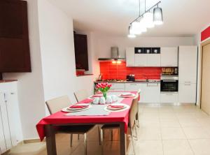 uma sala de jantar com uma mesa vermelha e cadeiras em B&B Continanza em Castelsaraceno