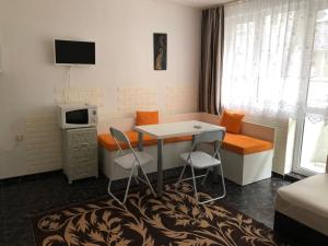 Zimmer mit einem Tisch und Stühlen sowie einem TV in der Unterkunft Боксониера Georgi Georgiev in Warna