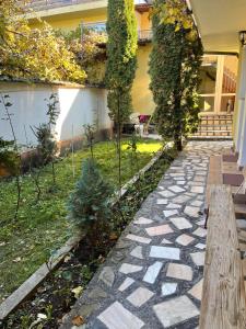 a garden with a stone walkway in front of a house at Casa Floraly in Braşov