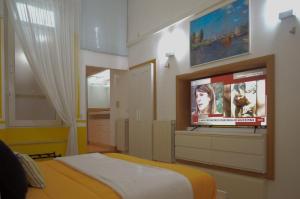 una camera con letto e TV a parete di B&B degli Artisti a Palmi
