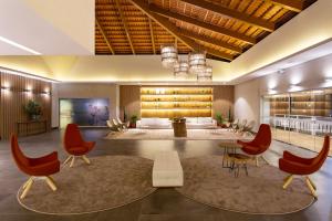 a lobby with red chairs and wine bottles at Ondas Praia Resort in Porto Seguro