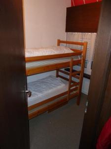 ラアにあるFerienwohnung Murschetgの二段ベッド2台とドアが備わる客室です。