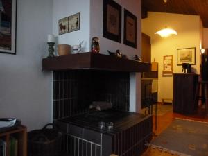 una sala de estar con chimenea y un estante encima. en Ferienwohnung Murschetg, en Laax