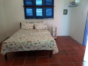 a bedroom with a bed with a floral bedspread at Casa em Águas Belas CE in Águas Belas +32 photos
