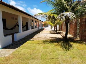 a building with a palm tree next to a courtyard at Casa em Águas Belas CE in Águas Belas