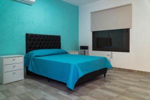 a blue bedroom with a bed and a television at Nomades Hostel in Alta Gracia