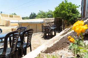 een groep tafels en stoelen in een tuin bij Nomades Hostel in Alta Gracia