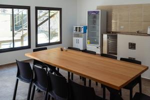 una sala de conferencias con mesa de madera y sillas en Nomades Hostel en Alta Gracia