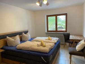 a bedroom with a bed with pillows and a window at Ferienwohnung Oberallgäu Ferienpark mit Schwimmbad in Missen-Wilhams +53 photos