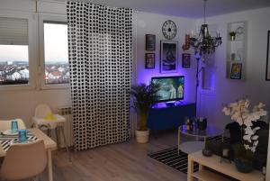 a living room with a tv and a purple wall at VG CityLux Apartment in Velika Gorica