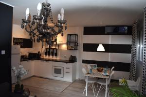 a kitchen with a chandelier and a table with chairs at VG CityLux Apartment in Velika Gorica