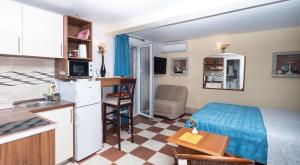 a small room with a bed and a kitchen at Apartmani Kamena Ruža in Budva