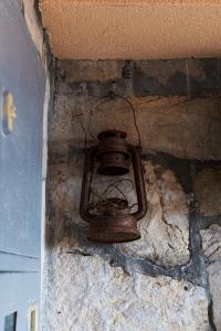 an old lamp in the corner of a stone wall at Apartmani Kamena Ruža in Budva