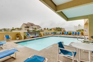a swimming pool with chairs and a table at Landfall Tower Unit 43 in South Padre Island