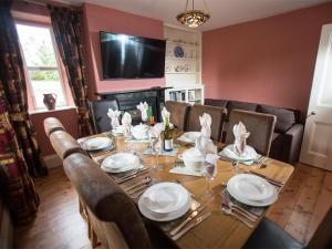 a dining room with a table with chairs and a television at Withy Cottages in Langport +47 photos