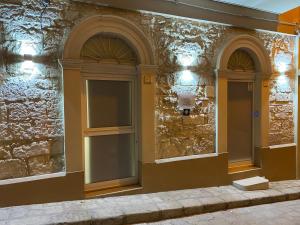 budynek z dwoma oknami i kamienną ścianą w obiekcie SiricyAus Luxury Room w mieście Ragusa