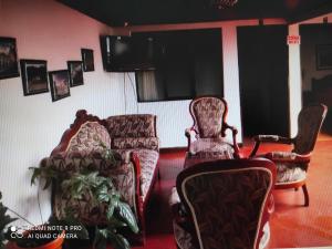 Una sala de estar con dos sillas y un televisor. en Hotel Don Blas, en Popayán
