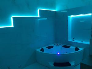 een witte badkamer met een bad met blauwe verlichting bij La Stella d'oro in Orvieto