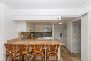 a kitchen with a marble counter top and wooden stools at Ilikai Tower 912 in Honolulu