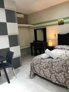 um quarto com uma cama, uma secretária e um espelho em Terracota Corner Rooms em Campeche