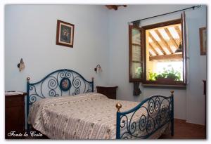 a bedroom with a blue bed and a window at Ortoturismo Fonte La Costa in Marciano