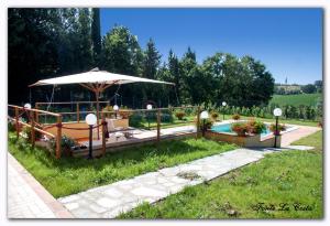 a garden with an umbrella and a swimming pool at Ortoturismo Fonte La Costa in Marciano