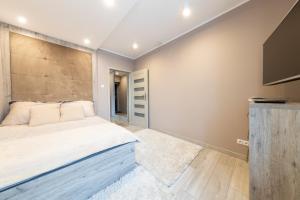 a bedroom with a large bed with a wooden headboard at APARTVIP Akademicka in Białystok