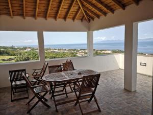 una mesa y sillas en un patio con vistas al océano en Casa do António Júlio en São Roque do Pico