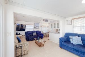 a living room with blue couches and a kitchen at Long Island Village Unit 278 in Port Isabel