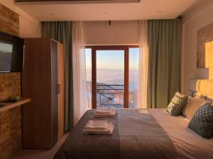 a hotel room with a bed with a large window at Mountain Bliss Residence - Milmari Spa & Wellness in Kopaonik