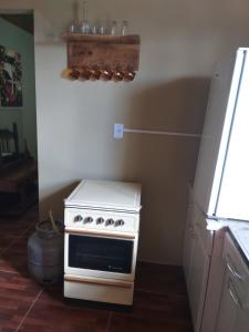 a kitchen with a white stove and a refrigerator at Edícula Prudentópolis in Prudentópolis