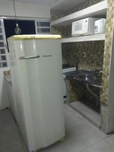 een kleine keuken met een koelkast en een magnetron bij cantinho bom in Ubatuba